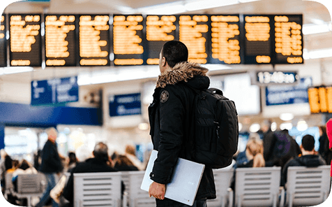 Traveler in airport looking at departure board